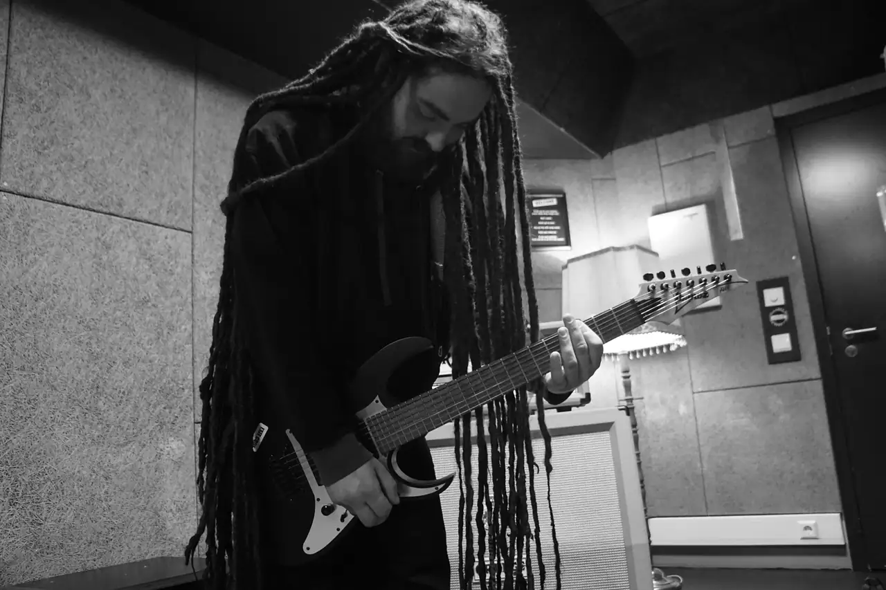 Adam playing guitar in the rehearsal room